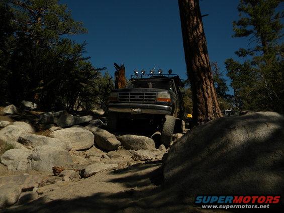 1992 Ford Bronco driving over rocks on a trail