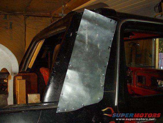 Black 1978 Ford Bronco side view with a metal panel riveted to the rear quarter panel