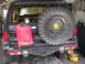 1988 Ford Bronco - Rear view of a black Ford Bronco with a spare tire mounted and a red jerry can on the bumper.