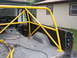 1988 Ford Bronco - The interior of a pickup truck bed shows a yellow roll cage and a trash can.