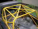 1988 Ford Bronco - A yellow roll cage is installed in the bed of a dark-colored truck.