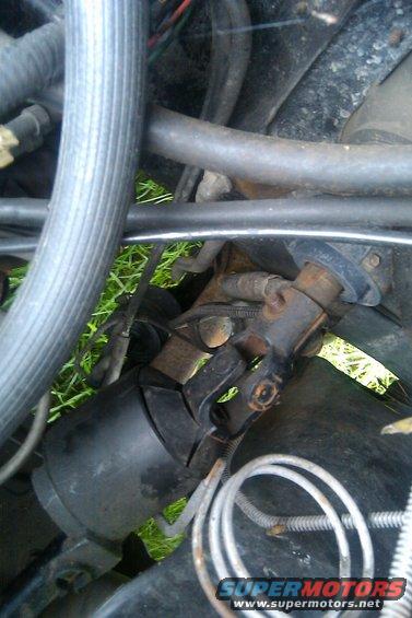 Close-up of a steering column universal joint with hoses and wires