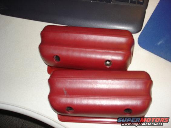 Two red armrests with visible mounting holes and minor scratches