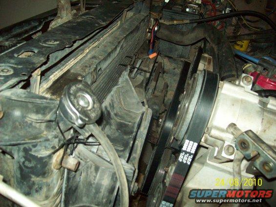 Close-up of engine bay showing radiator, belts, and part of the AC compressor