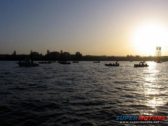 Boats on water at sunset with city skyline