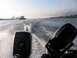 1996 Ford Bronco - View from a boat moving through the water, showing two outboard motors and a distant barge.