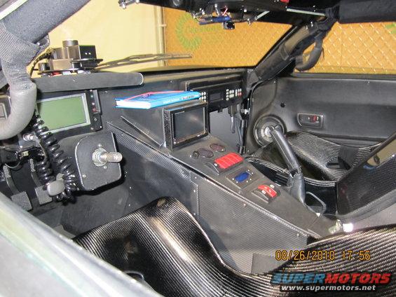 Custom dashboard with screens, switches, and carbon fiber trim. Gear shifter visible