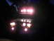 1988 Ford Bronco - An SUV is illuminated by numerous bright auxiliary lights mounted on its roof and front bumper.