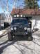 1988 Ford Bronco - Front view of a modified Jeep Cherokee with off-road tires and auxiliary lights.