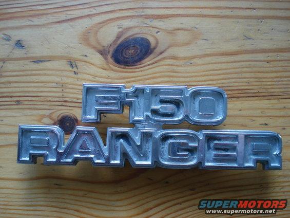 Chrome F150 and Ranger emblems on a wooden surface
