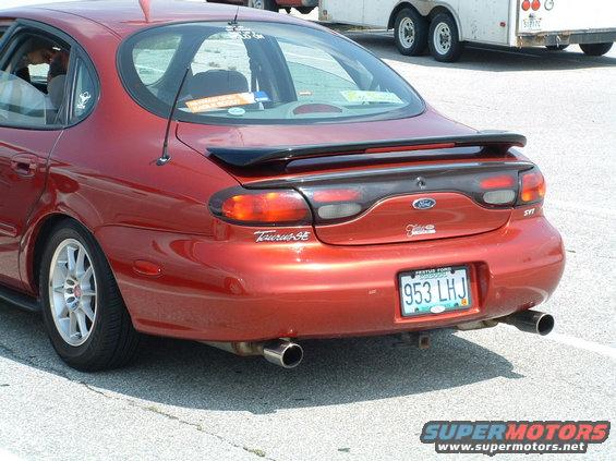 Red 1993 Ford Taurus SE with spoiler and custom wheels