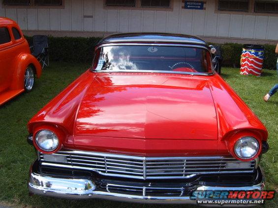 Red 1956 Ford Fairlane front view with chrome grille and black roof