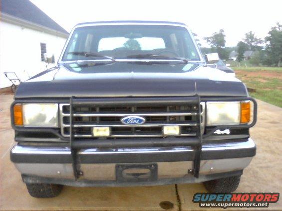 Front view of a black 1990 Ford Bronco with a brush guard and 4x4 badging