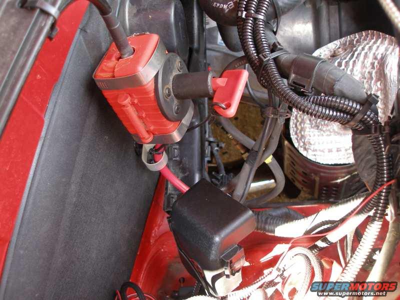Red battery disconnect switch with a red lever, mounted in engine bay with wiring
