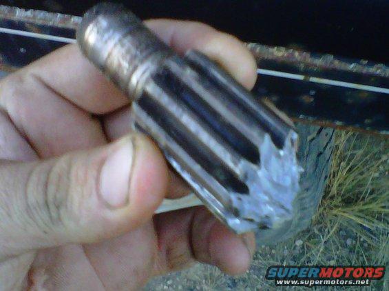 Hand holding a damaged metal gear with splines