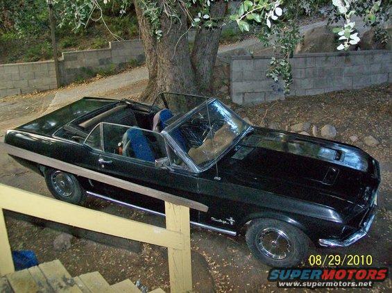 1968 Ford Mustang convertible parked outdoors, front quarter view. Hood scoop and side trim visible