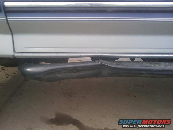 Damaged running board on a silver vehicle with blue trim