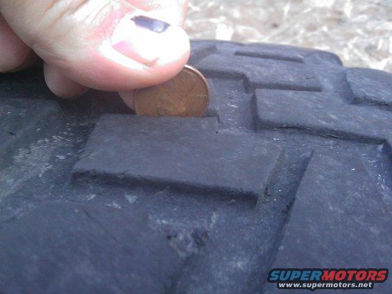 Penny inserted into tire tread to show depth