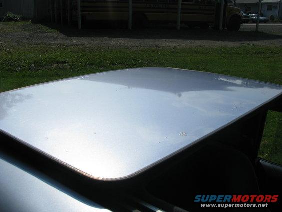 Silver car sunroof with water spots, viewed from above