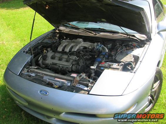 Silver 1994 Ford Probe with hood open, showing the engine bay. Ford logo on the front