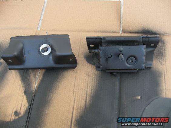 two black metal engine mounts on a cardboard surface