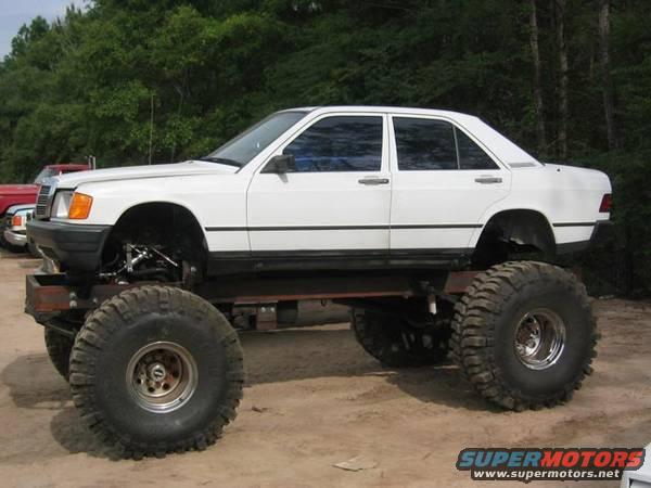 White Mercedes-Benz sedan with monster truck tires, side view