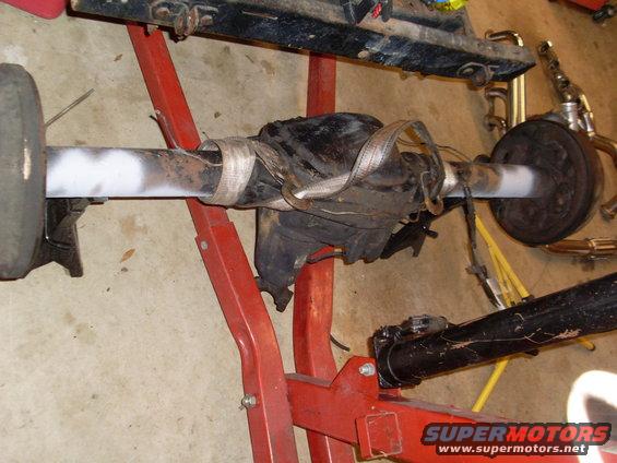 Rear axle assembly on a red stand with Supermotors.net logo