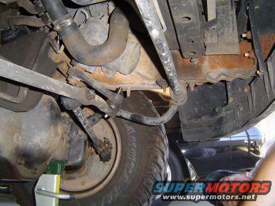 Undercarriage view showing steering linkage, suspension parts, and a tire