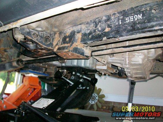 Underside view of vehicle frame and transmission with jacks supporting it