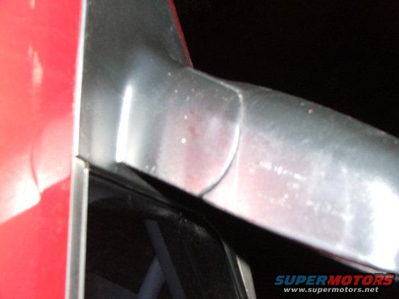 Red vehicle door edge with chrome trim detail