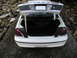 2001 Audi A4 - The trunk of a white police car is open, showing a spare tire and a wooden prop rod holding the trunk lid up.