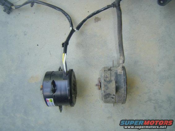 Two electric cooling fans, one new black, one old grey, with wiring harnesses on a concrete surface