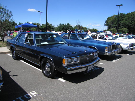 Dark blue sedan parked in a lot, front quarter view. License plate reads '1282855'
