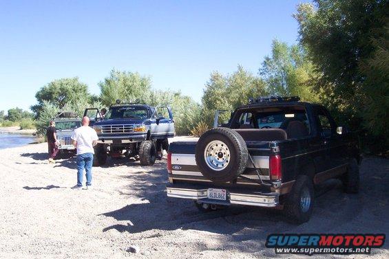 Black Ford Bronco rear view with spare tire mounted on the back, lifted suspension, and roof rack