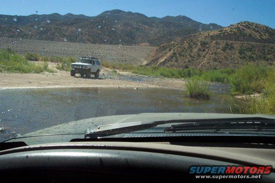 White 1995 Ford Bronco crossing stream