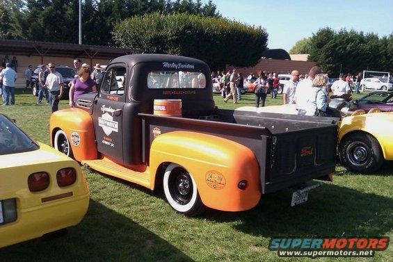 Black and orange Ford F-Series pickup truck with Harley-Davidson logos, seen from the rear 3/4 view