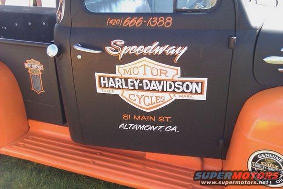 Side view of a vintage pickup truck door with Speedway Harley-Davidson Cycles logos and address