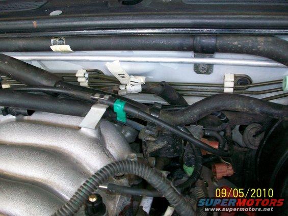 Close-up of engine bay with black hoses and some white tape labels