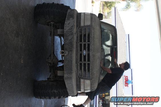 1992 Ford Bronco front view, covered in mud, with large off-road tires