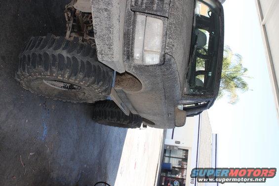 1992 Ford Bronco covered in mud, large off-road tires visible