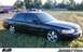 1995 Ford Crown Victoria - This black sedan is parked outdoors on a grassy area with buildings and other vehicles visible in the distance.