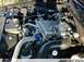 1995 Ford Crown Victoria - Close-up of an engine bay a supercharger and braided hoses, with a Ford logo visible on a cap.
