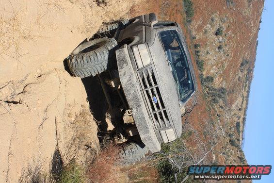 Gray 1992 Ford Bronco tilted on a steep dirt trail