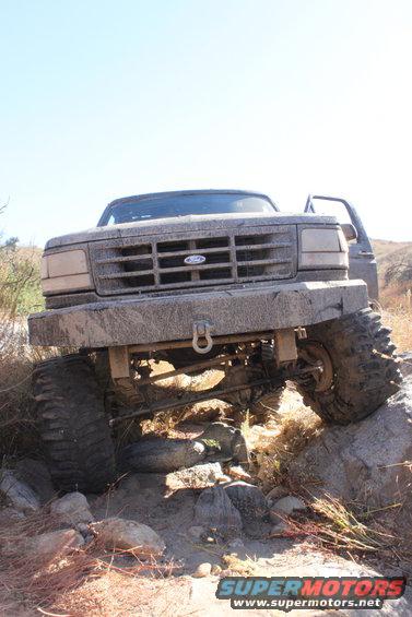 Ford Bronco climbing over rocks on a trail, front view