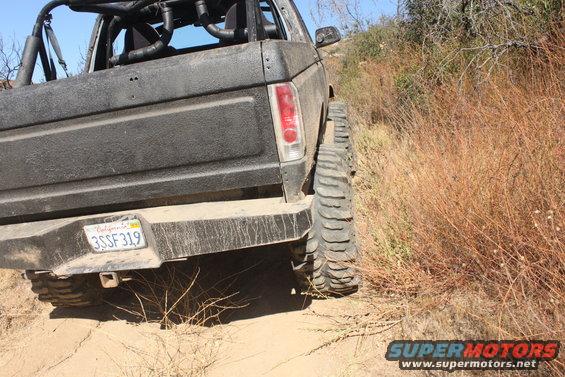1992 Ford Bronco rear view, off-roading on dirt with large tires