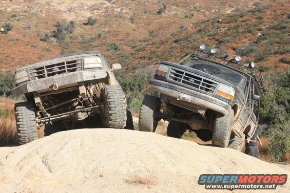 Two 1992 Ford Broncos climbing a rocky hill off-road