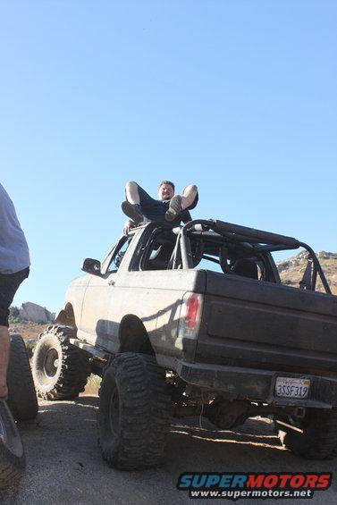 1992 Ford Bronco lifted with large tires, person sitting on roof, California license plate 3SSF319