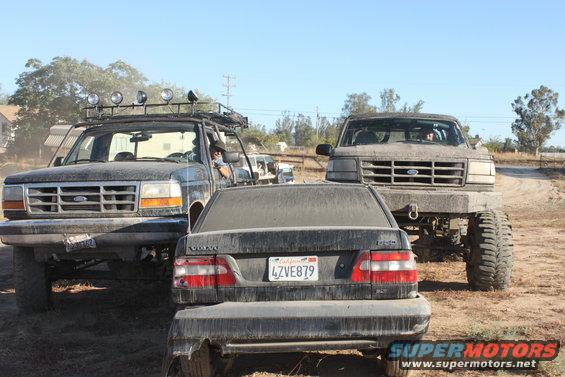 1992 Ford Bronco with roof rack and lights, front view, covered in dust