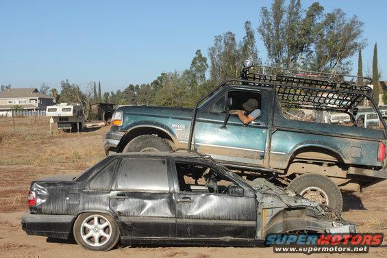 Green 1992 Ford Bronco on top of a severely damaged black sedan