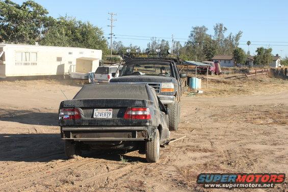Black sedan's rear end towed by lifted truck; license plate 4ZVE879